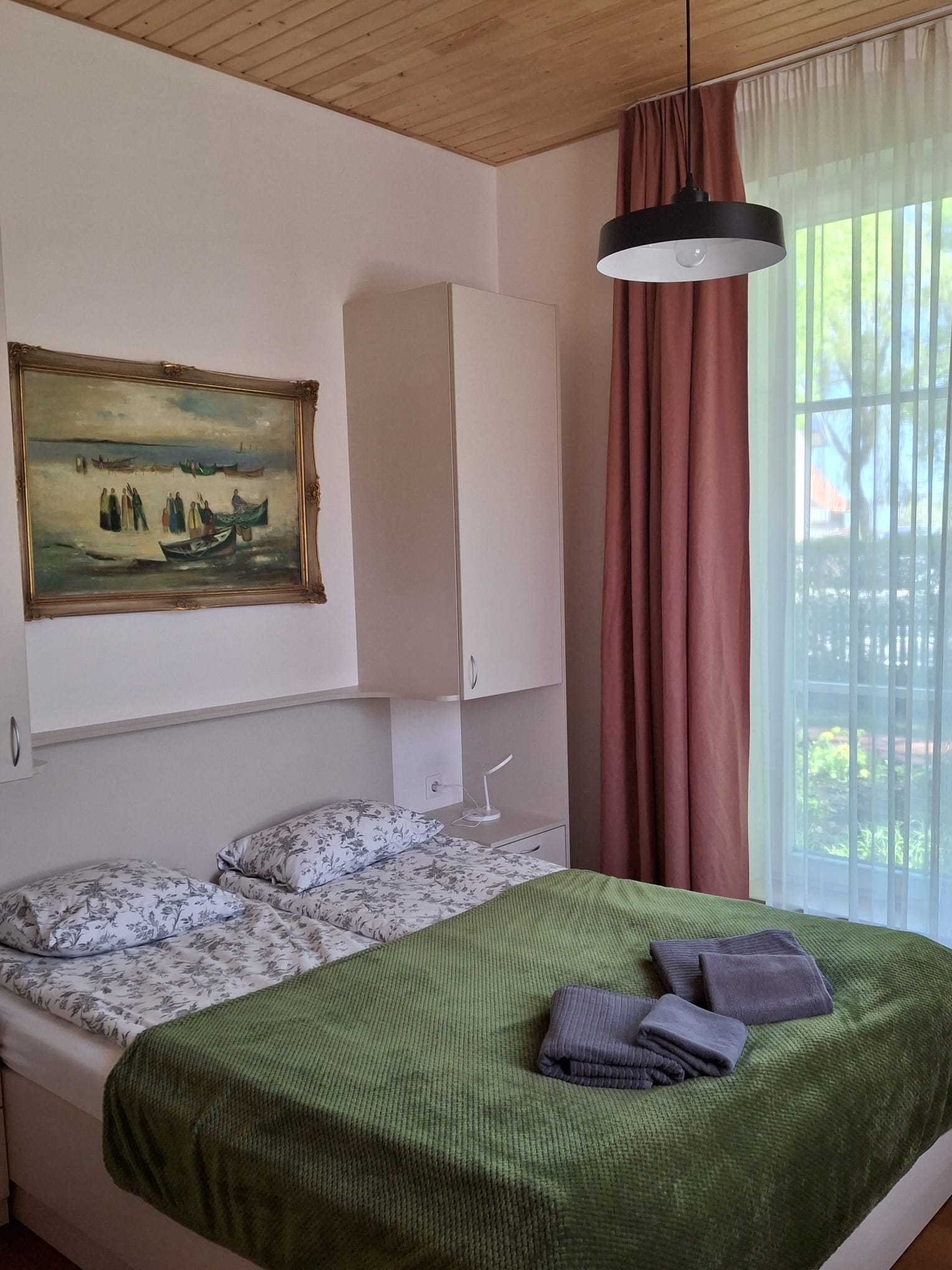 Doppelzimmer im Haus Aika – Bett mit grüner Tagesdecke
